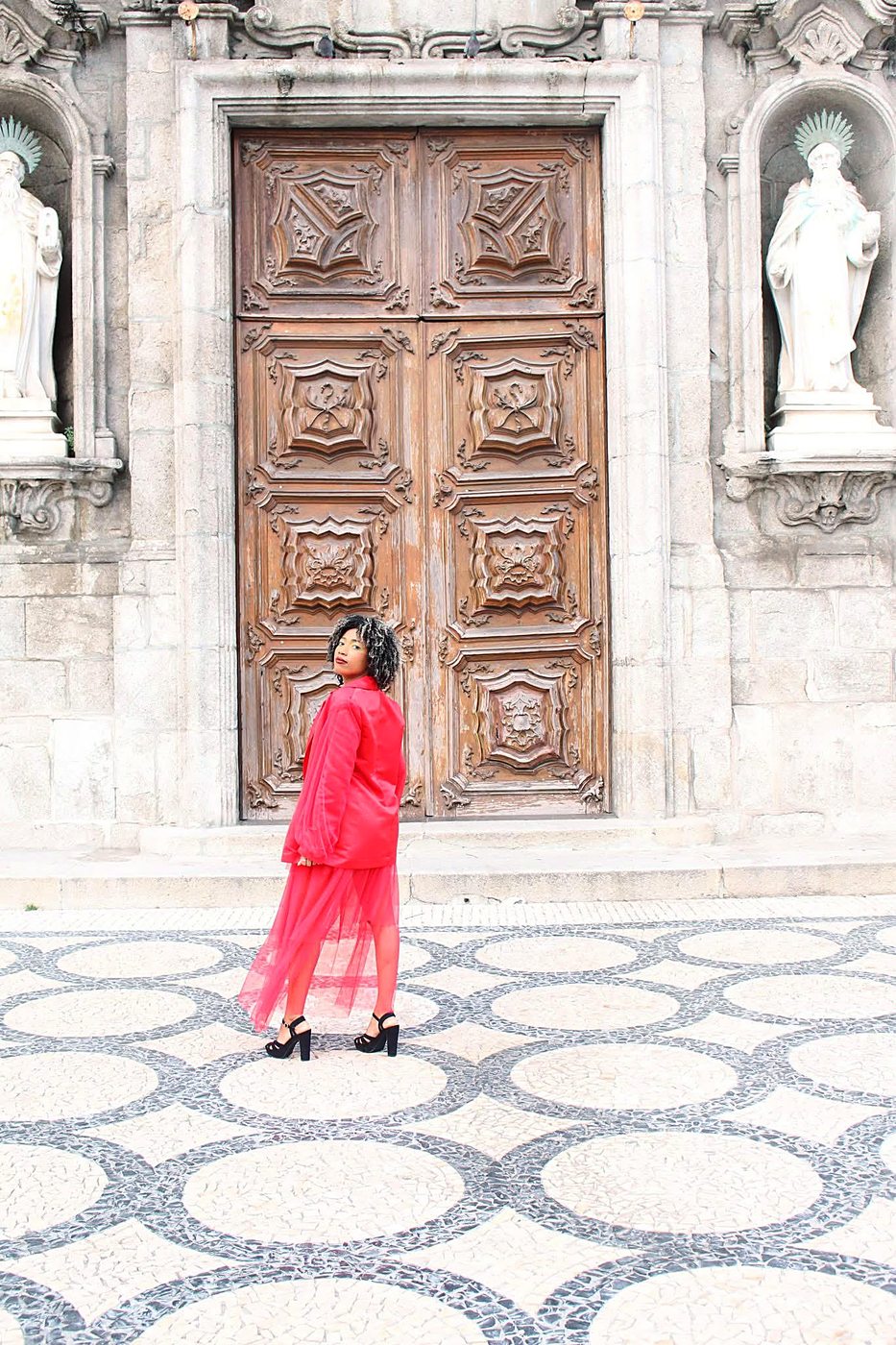 Look Flame Scarlet em plano geral, diante das portas de uma igreja do Porto