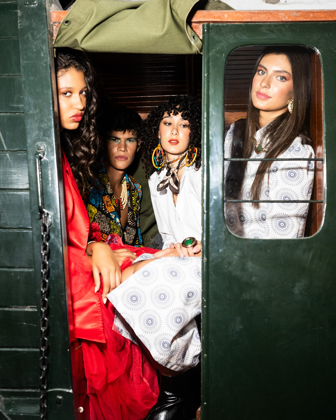 Quatro modelos na cabine de um camião vintage, em looks Flame Scarlet, estampados e Bright White