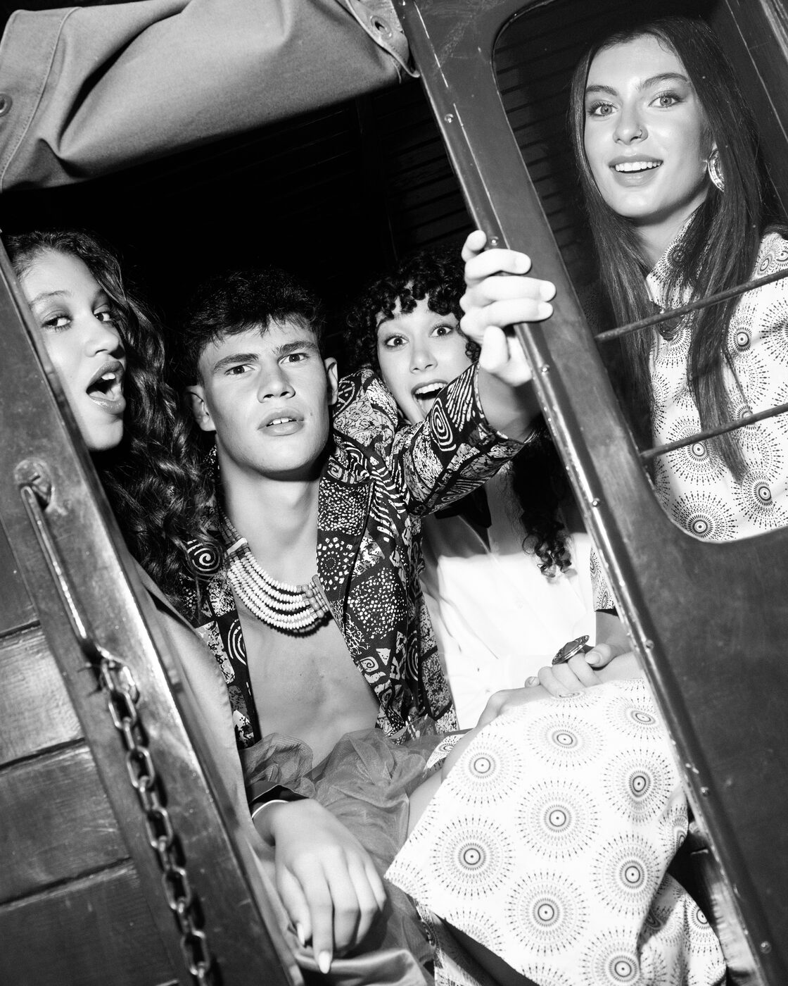 Fotografia a preto e branco: quatro modelos divertem-se à janela da cabine do camião vintage