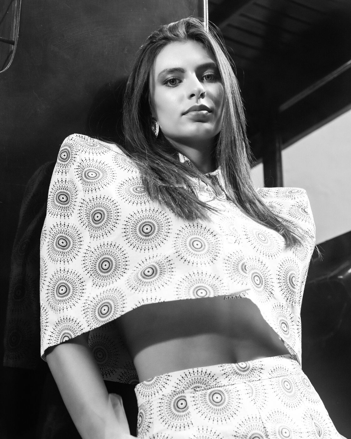 Fotografia a preto e branco: modelo em conjunto estampado de ombros estruturados, em contrapicado